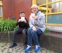 Die beiden Schüler Alessandro und Johneson zeigen ihr Seepferdchen-Abzeichen